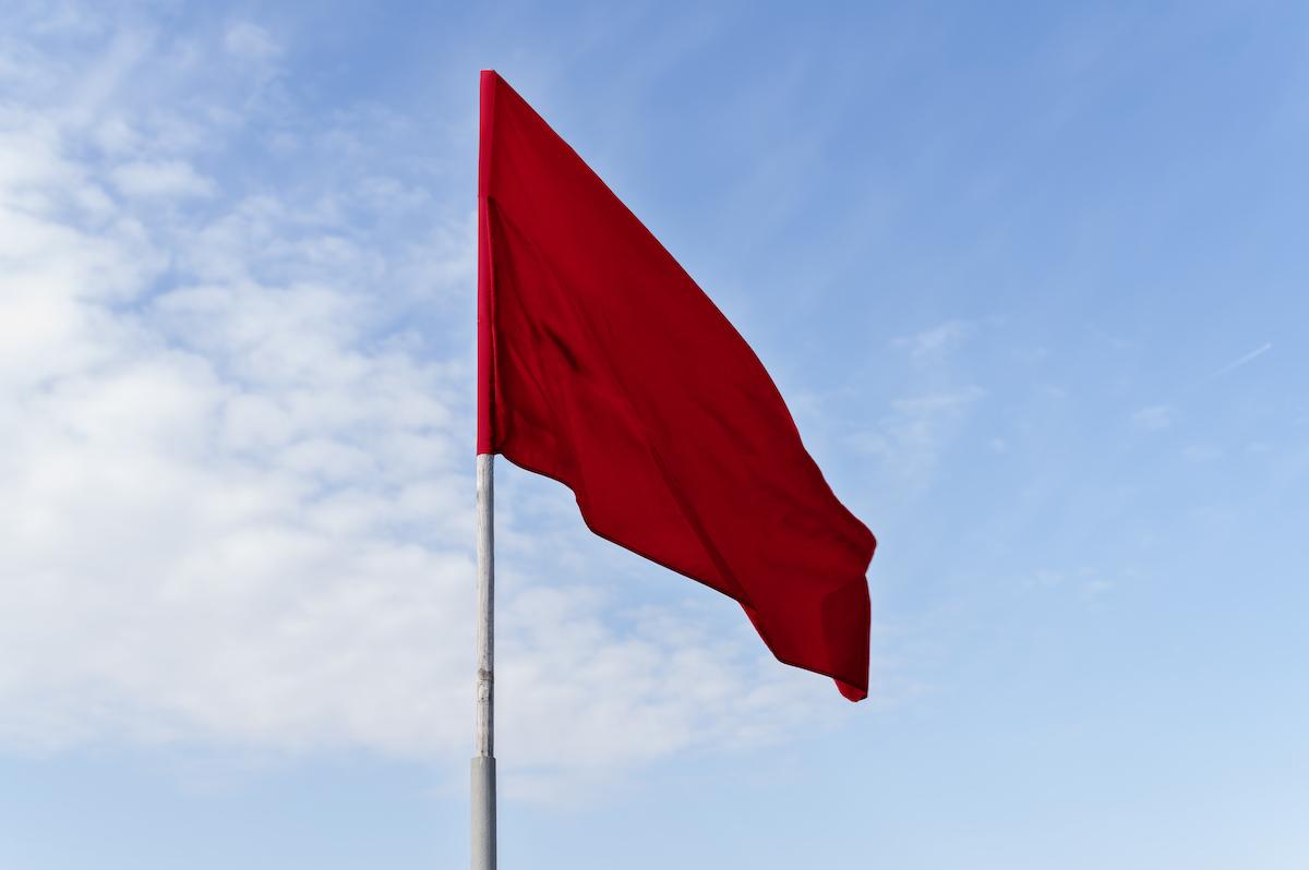 Rode vlag tegen een blauwe lucht van de Reddingsbrigade
